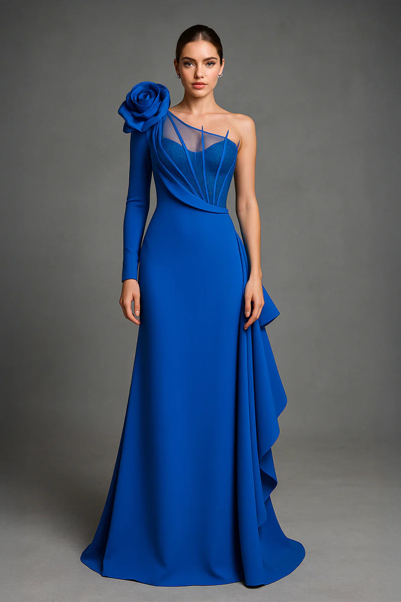 Woman wearing a blue evening gown with a large floral embellishment on a gray background